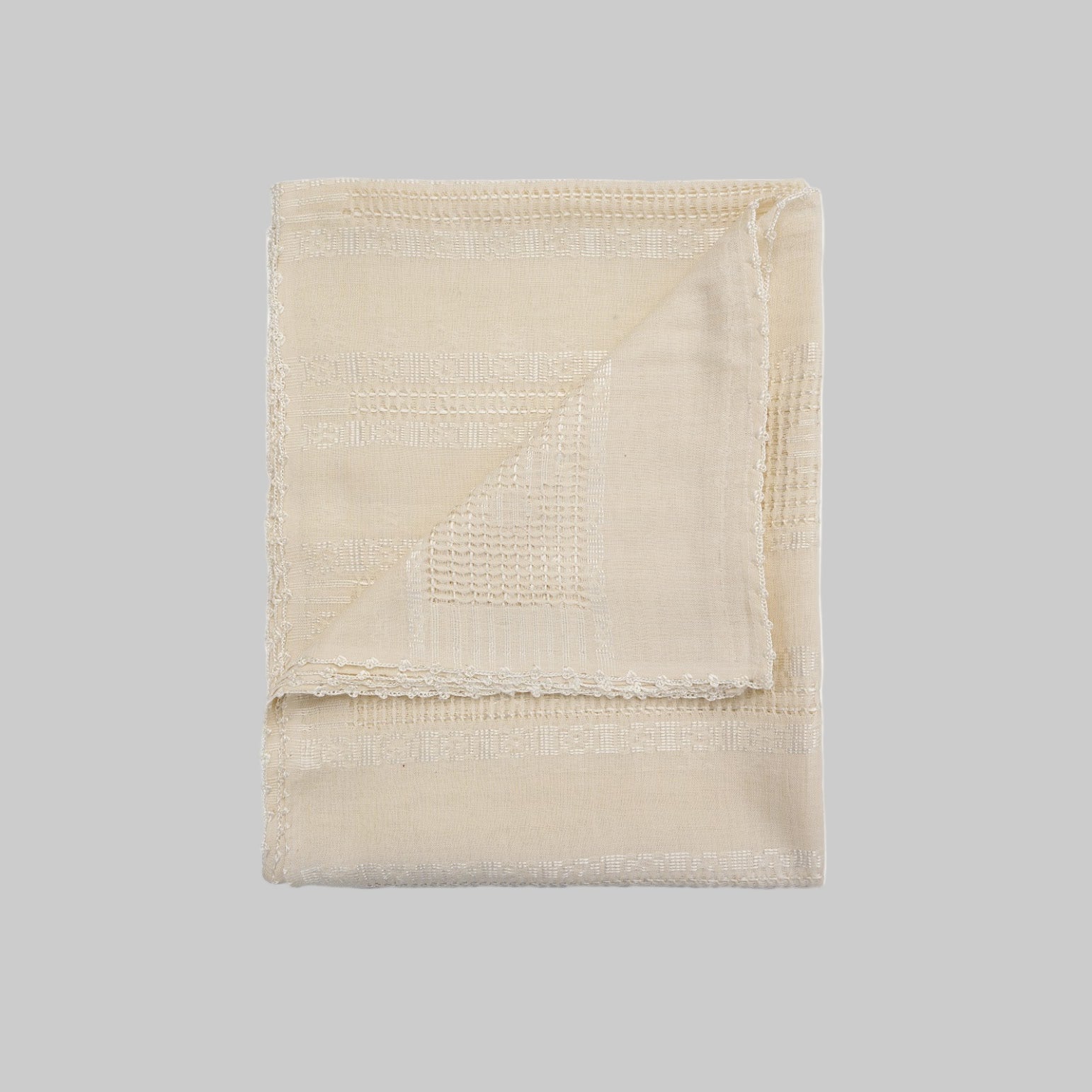 Folded beige blanket on a white background